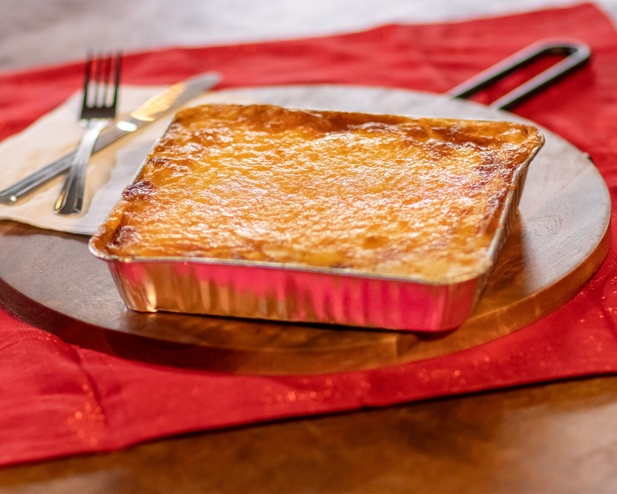 A golden cottage pie with a portion of its potato top removed to reveal its hearty filling A golden cottage pie ready for eating