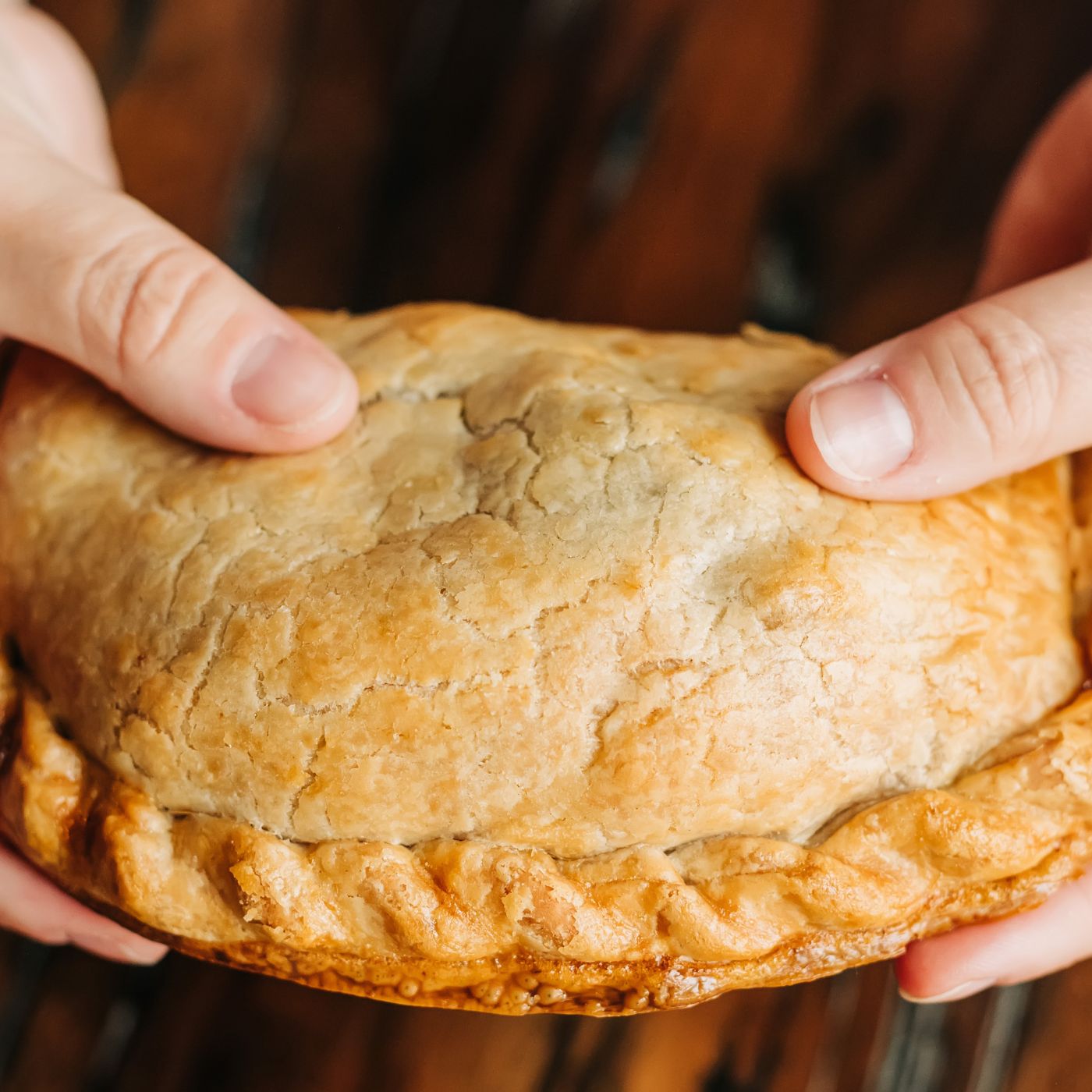 A woman holding an authentic, scratch-made Cornish pasty.