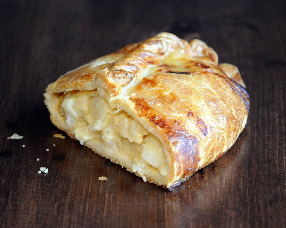 
                  
                    A cheese and onion pasty cut in half to reveal its filling of potato, onion, cheddar cheese, and fontina cheese
                  
                