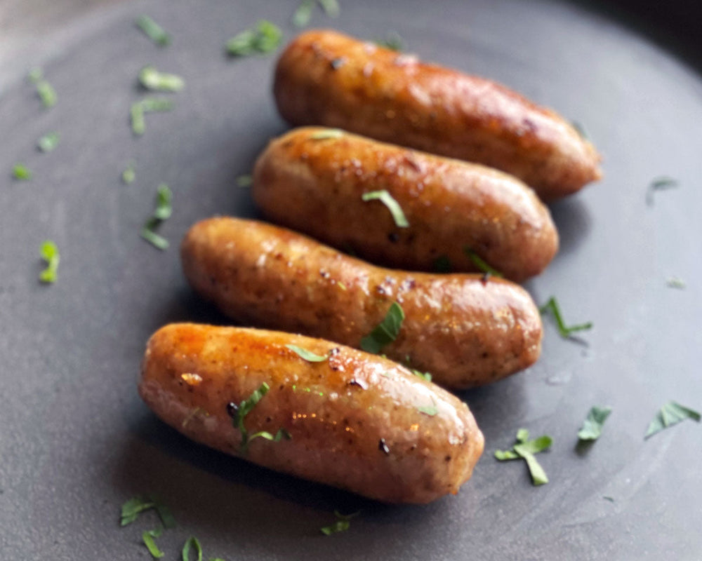 
                  
                    Four golden English bangers ready for eating
                  
                